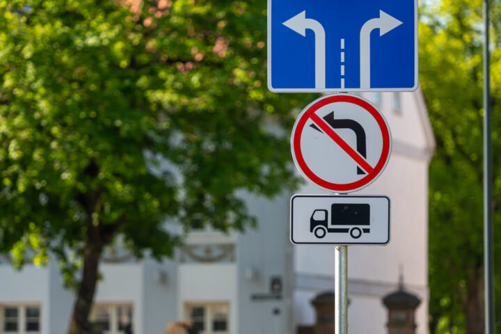 Dopravné značky na stĺpe v obytnej zóne — informačná, zákazová a dodatková tabuľka.