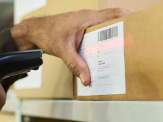 Ilustračný stock: skenovanie kartónu a GS1 barcode civilne, bez WMS UI.